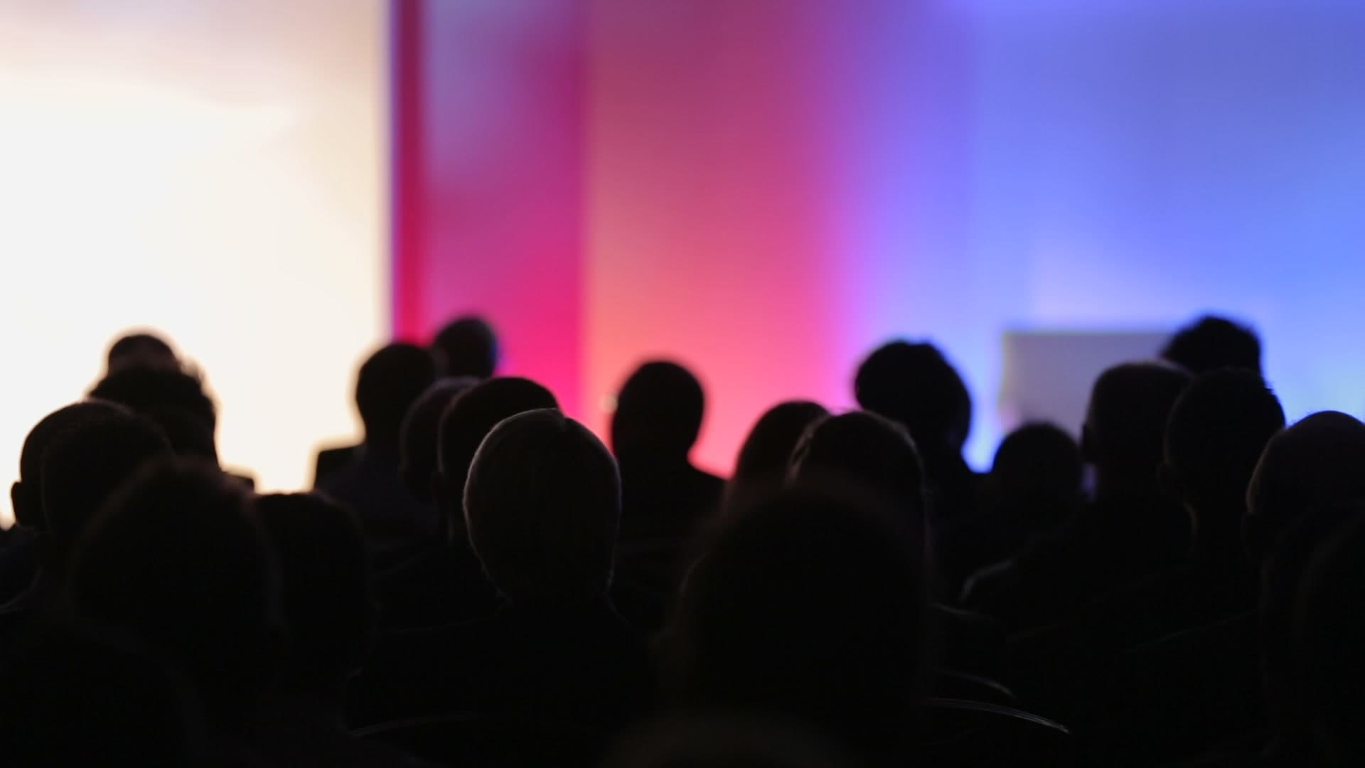 Silhouette of a seated crowd at a conference event